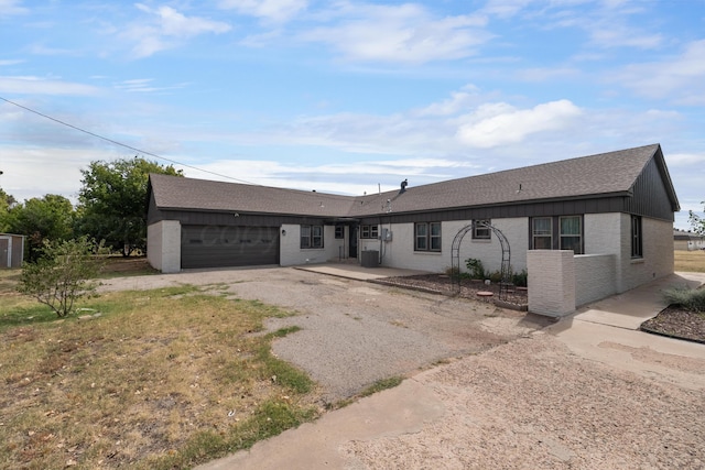 single story home with a garage and central AC unit