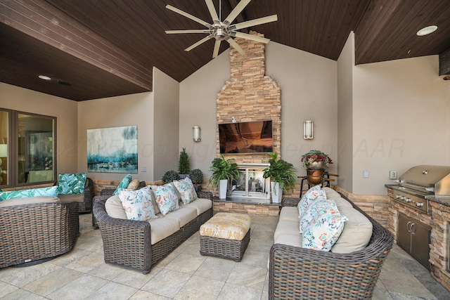 view of patio / terrace with a ceiling fan, an outdoor living space with a fireplace, exterior kitchen, and area for grilling