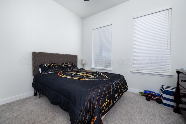 carpeted bedroom with lofted ceiling and baseboards
