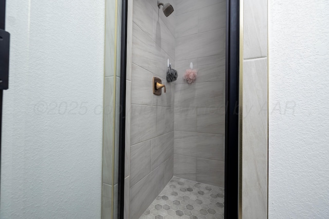 bathroom with a shower stall and a textured wall