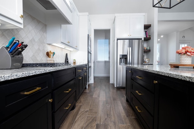 kitchen featuring white cabinets, dark cabinetry, wall chimney range hood, and stainless steel appliances