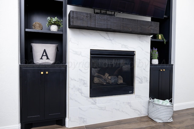 interior details with wood finished floors, baseboards, and a high end fireplace