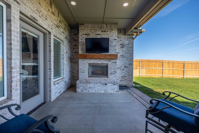 view of patio / terrace featuring an outdoor brick fireplace and fence
