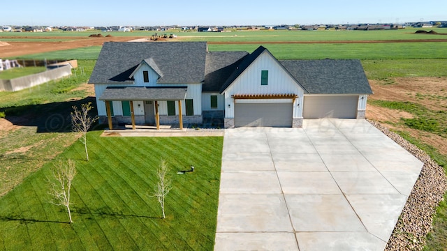 view of front of house with a front lawn, concrete driveway, an attached garage, a porch, and roof with shingles