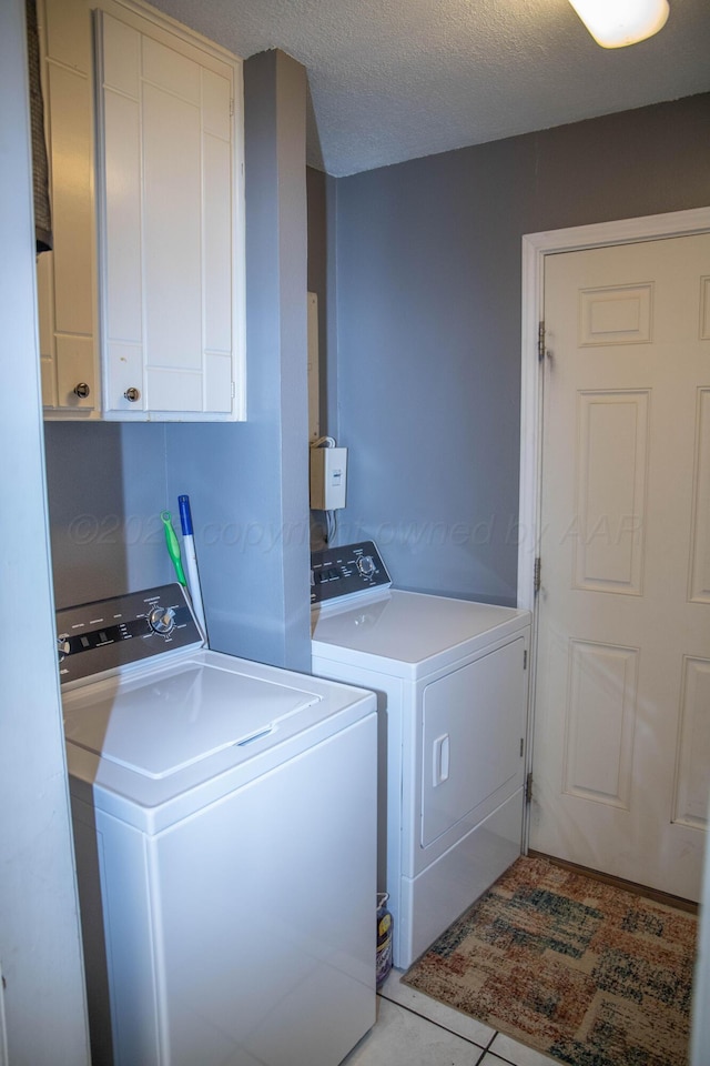 1403 Charles Ave, Panhandle, TX 79068 - washroom with washer and clothes dryer, cabinet space, a textured ceiling, and light tile patterned flooring