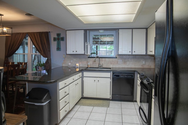 1403 Charles Ave, Panhandle, TX 79068 - kitchen featuring black appliances, light tile patterned floors, a peninsula, white cabinetry, and tasteful backsplash