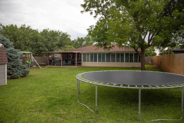1403 Charles Ave, Panhandle, TX 79068 - fenced backyard with a trampoline, a sunroom, and a playground