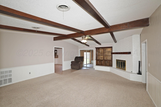 3519 Rutson Dr, Amarillo, TX 79109 - unfurnished living room featuring carpet flooring, a wainscoted wall, ceiling fan, a fireplace, and a textured ceiling