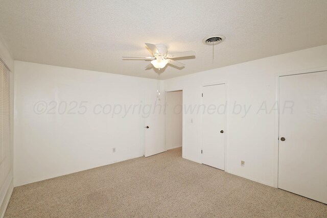 3519 Rutson Dr, Amarillo, TX 79109 - unfurnished bedroom featuring light colored carpet, two closets, a textured ceiling, and ceiling fan