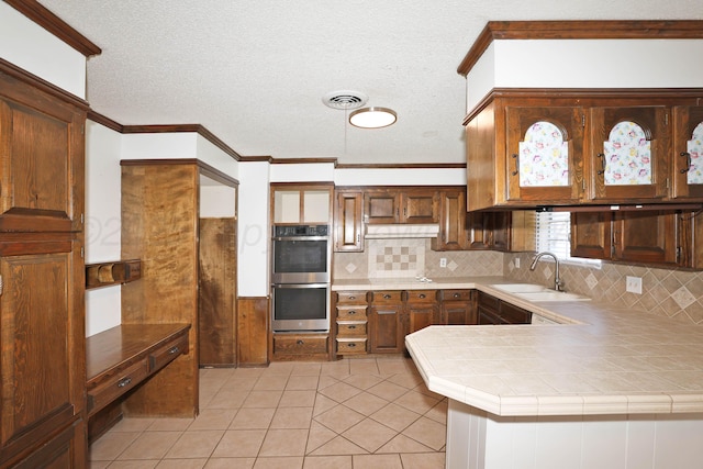 3519 Rutson Dr, Amarillo, TX 79109 - kitchen with a sink, stainless steel double oven, tasteful backsplash, light tile patterned floors, and ornamental molding