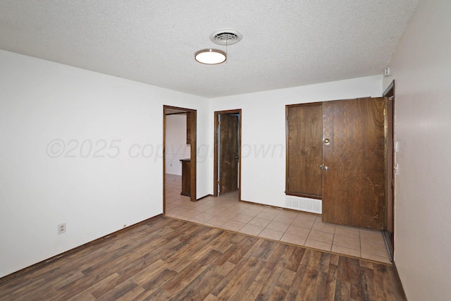 3519 Rutson Dr, Amarillo, TX 79109 - unfurnished bedroom with wood finished floors, a textured ceiling, and baseboards