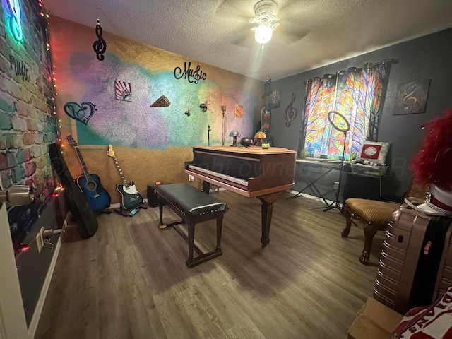 misc room featuring hardwood / wood-style floors, a textured ceiling, and ceiling fan