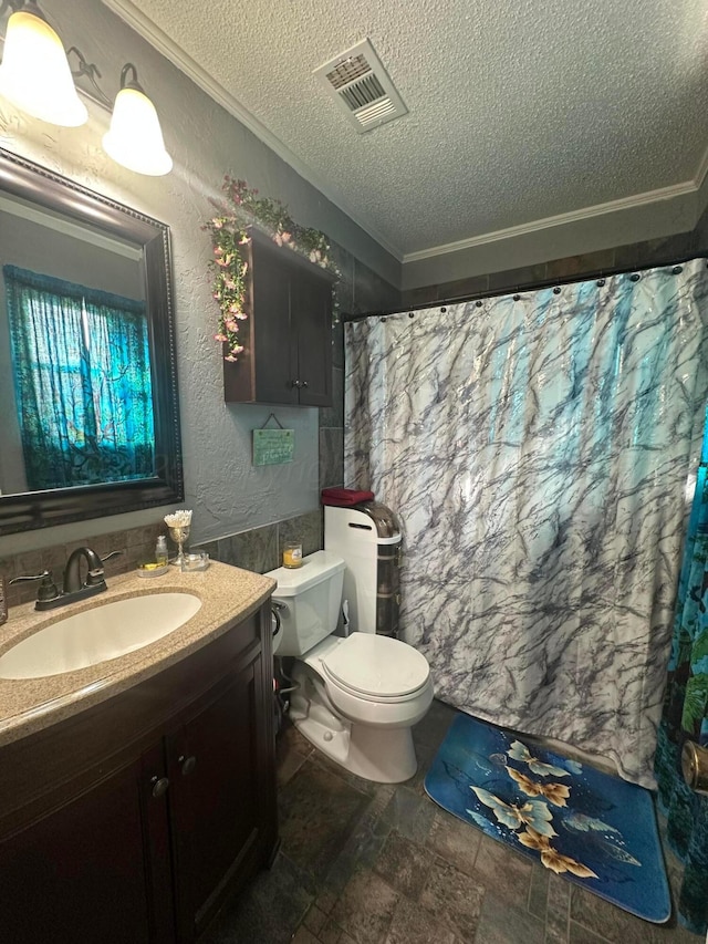 bathroom featuring ornamental molding, vanity, toilet, and a textured ceiling