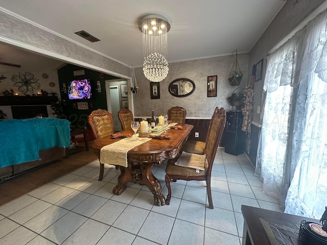 tiled dining area with crown molding and a notable chandelier