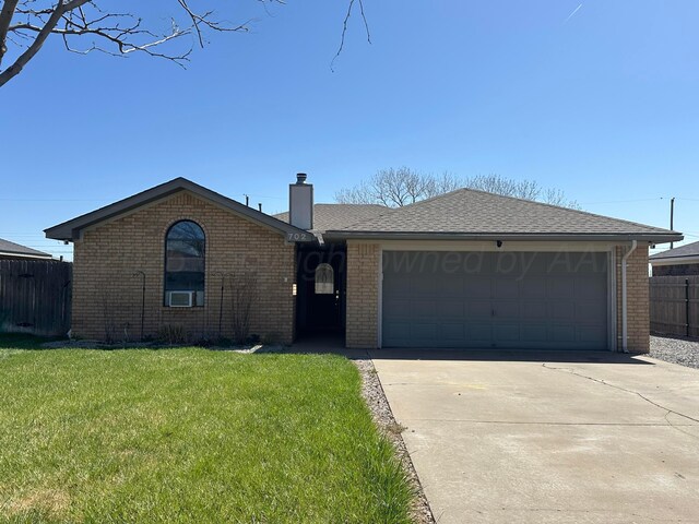 single story home with a garage and a front lawn