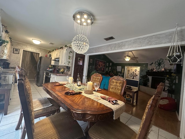 dining room featuring ornamental molding, ceiling fan with notable chandelier, and light tile patterned flooring