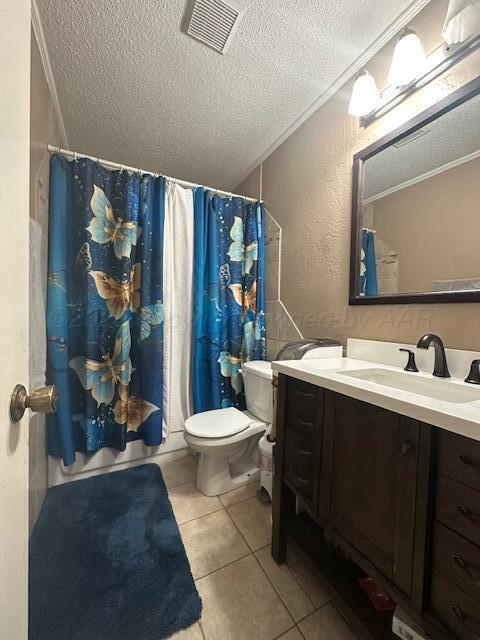 bathroom with tile patterned floors, toilet, crown molding, a textured ceiling, and vanity