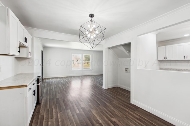 interior space featuring dark wood-type flooring, decorative light fixtures, crown molding, and white cabinets