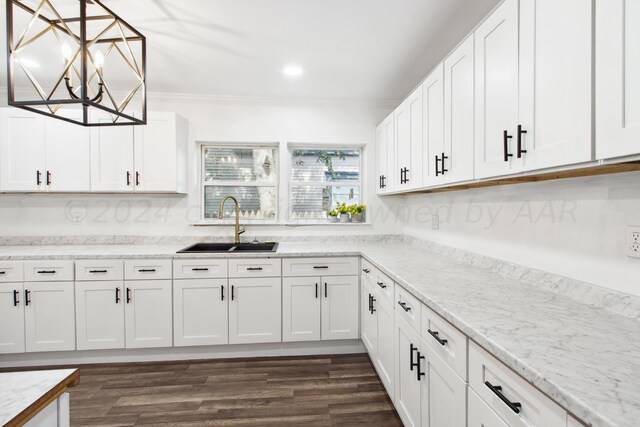 kitchen featuring white cabinets, hanging light fixtures, sink, and dark wood-type flooring