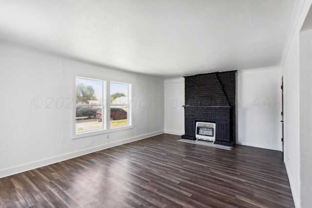 unfurnished living room featuring ornamental molding, a fireplace, dark wood-type flooring, and heating unit