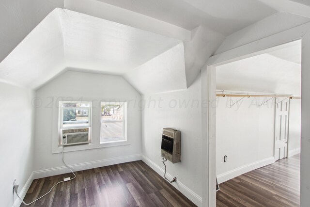 additional living space featuring dark wood-type flooring, heating unit, vaulted ceiling, and cooling unit