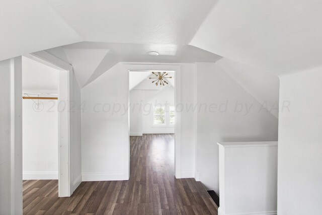 bonus room with dark wood-type flooring and vaulted ceiling