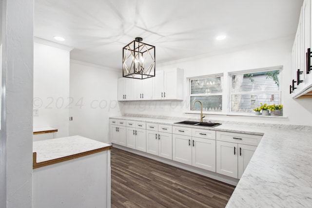 kitchen with pendant lighting, dark wood-type flooring, white cabinets, and sink