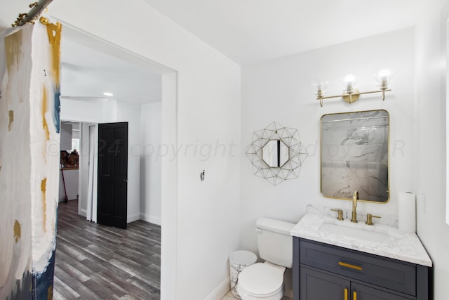 bathroom with hardwood / wood-style floors, vanity, and toilet