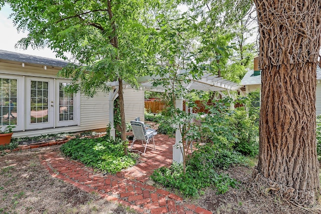 view of yard featuring fence, a patio area, and french doors