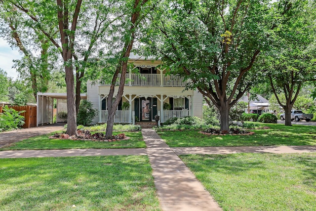 view of front of property with a porch, an attached carport, a balcony, and driveway