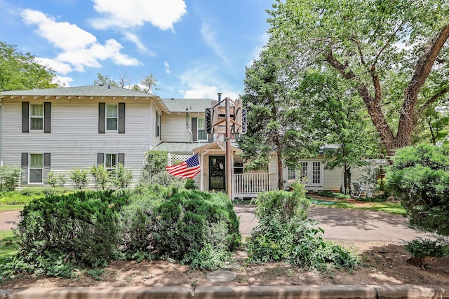 rear view of property featuring a shingled roof