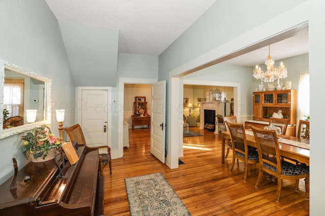 dining room featuring a fireplace, hardwood / wood-style flooring, and a chandelier