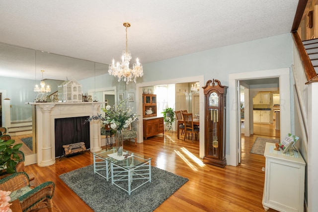 living area featuring a chandelier, light wood-style flooring, and stairway
