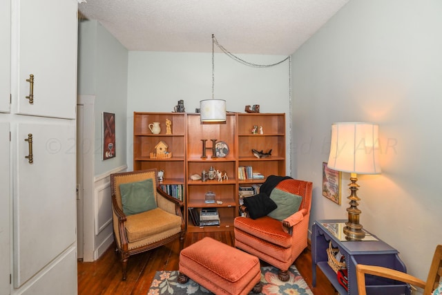 sitting room featuring wood finished floors and a textured ceiling