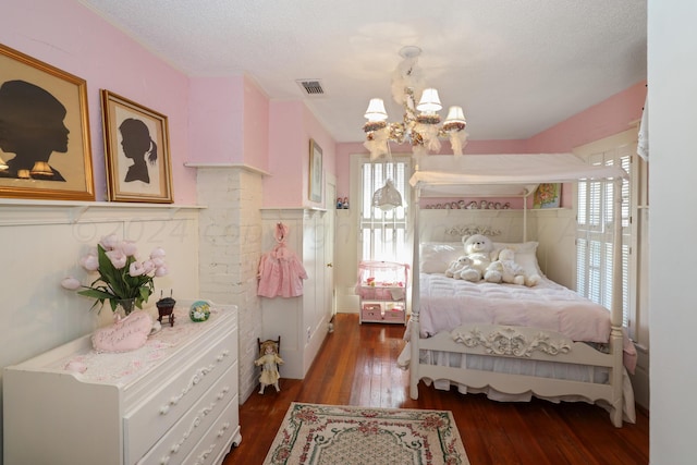 bedroom featuring a chandelier, multiple windows, hardwood / wood-style floors, and a textured ceiling