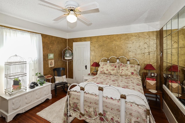 bedroom with wood finished floors, a textured ceiling, and a ceiling fan