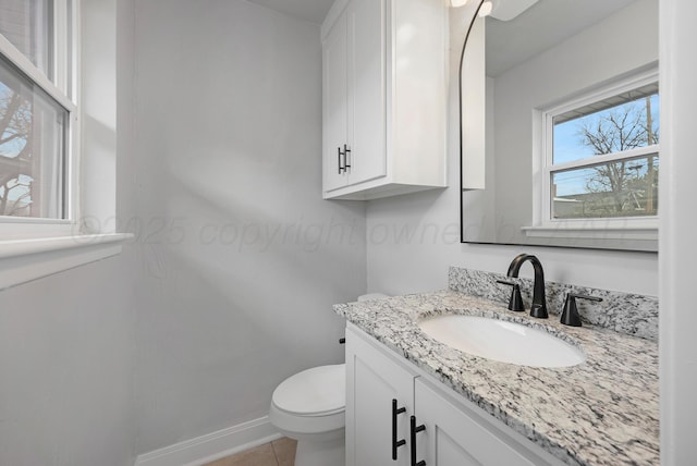 half bathroom featuring vanity, toilet, baseboards, and tile patterned floors