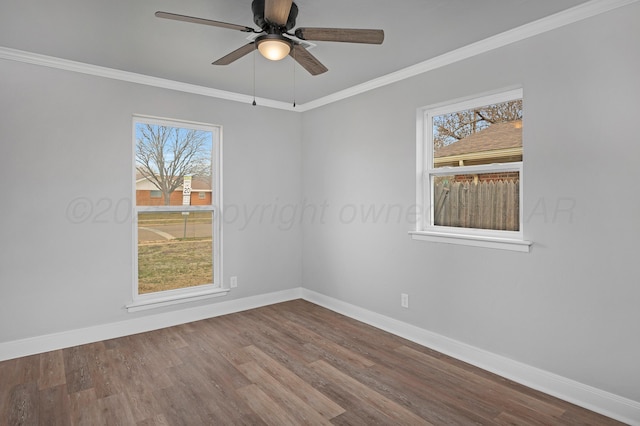 spare room with baseboards, dark wood-style flooring, plenty of natural light, ornamental molding, and a ceiling fan
