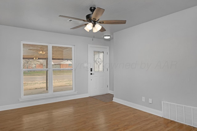 empty room featuring baseboards, ceiling fan, and wood finished floors
