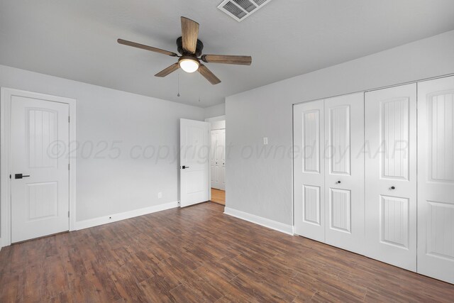 unfurnished bedroom featuring baseboards, dark wood-style floors, a closet, and ceiling fan