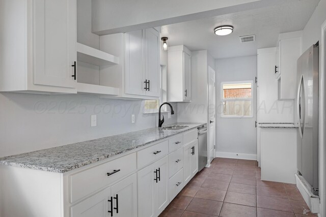 kitchen with open shelves, stainless steel appliances, a sink, and white cabinetry