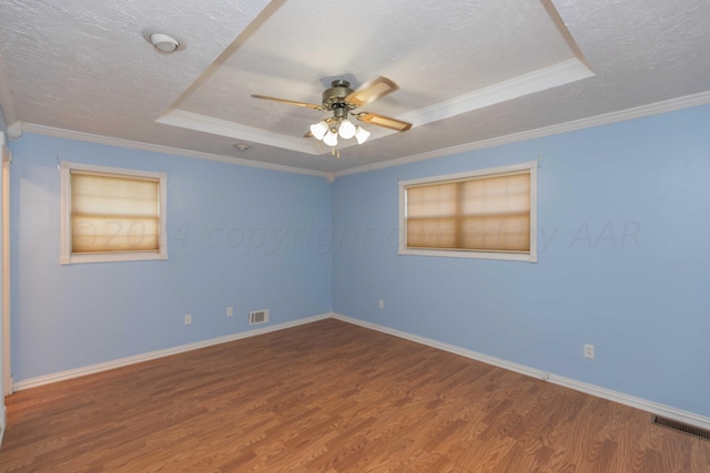 empty room featuring a textured ceiling, wood finished floors, visible vents, and a ceiling fan