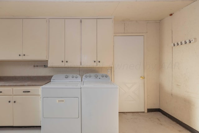 laundry room with baseboards, independent washer and dryer, and cabinet space