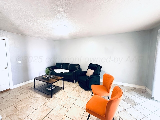 living room with baseboards and a textured ceiling