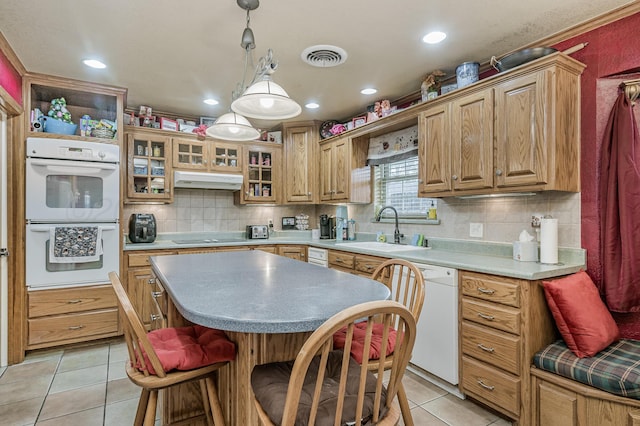 7216 Gainsborough Rd, Amarillo, TX 79106 - kitchen with a sink, white appliances, light tile patterned floors, under cabinet range hood, and decorative backsplash