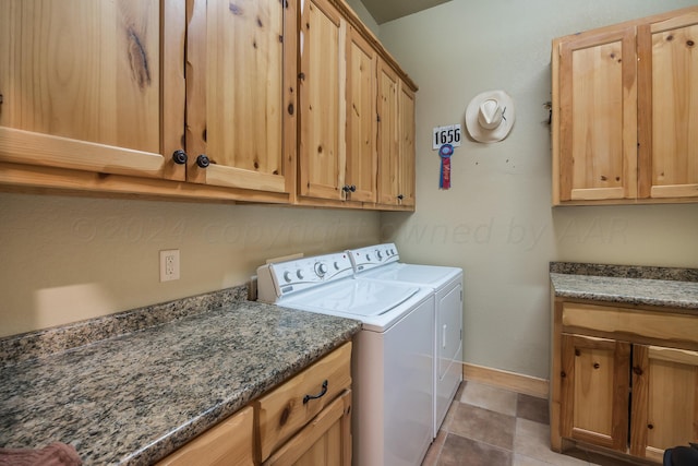 clothes washing area with washer and dryer, tile patterned floors, and cabinets