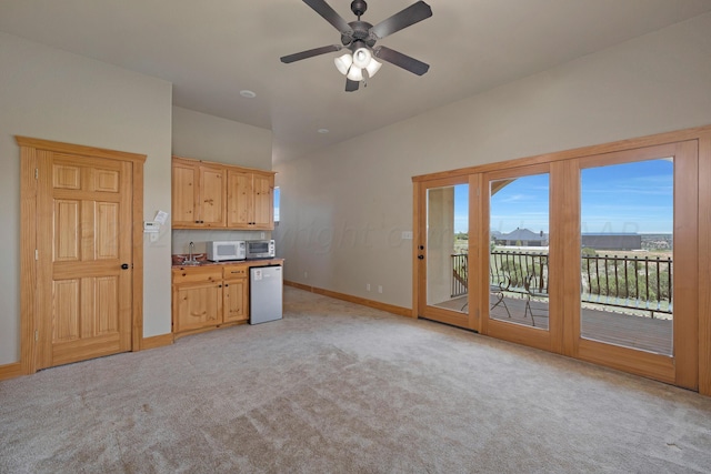 kitchen featuring ceiling fan, light brown cabinets, and light carpet