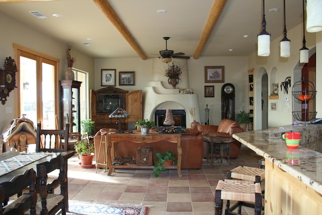 tiled dining space with beam ceiling and ceiling fan