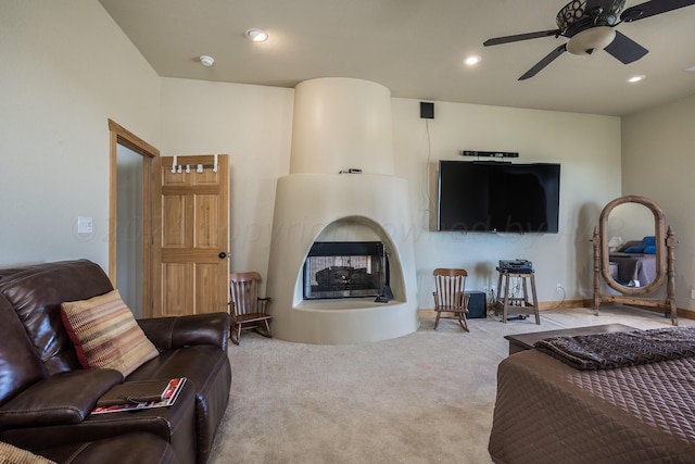 carpeted living room featuring ceiling fan and a multi sided fireplace