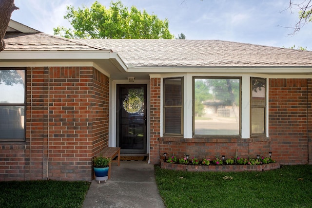 5701 Durrett Pl, Amarillo, TX 79109 - view of exterior entry featuring brick siding and a shingled roof